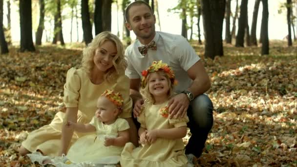 Heureux jeune famille avec leurs enfants passer du temps en plein air dans le parc d'automne — Video