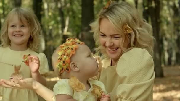 Молода щаслива мати і її діти з клеоном в осінньому парку — стокове відео