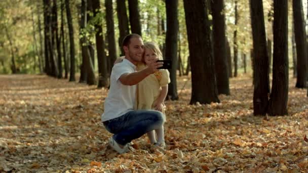 Glad familj med selfie med smartphone i höst park — Stockvideo