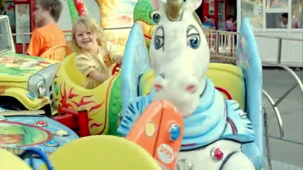Flicka som rider en färgglad karusell — Stockvideo