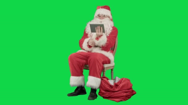 Babbo Natale utilizzando computer tablet per navigare in internet e comunicare nei social media con i bambini su uno schermo verde Chrome Key — Video Stock