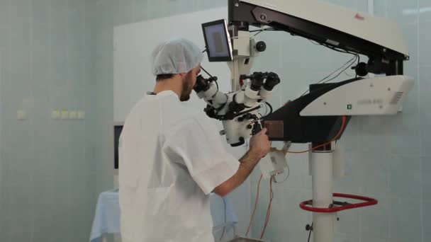 Ο άνθρωπος χρησιμοποιεί ένα μεγάλο σύστημα μικροσκόπιο σε ένα ιατρικό εργαστήριο — Αρχείο Βίντεο