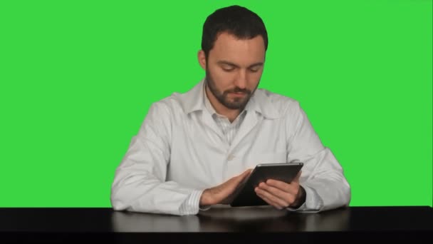 Врач-мужчина с цифровым планшетом в медицинском кабинете на зеленом экране, ключ хромы — стоковое видео