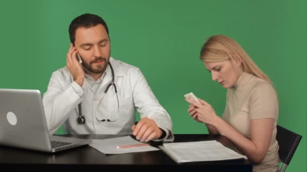 Серьезный врач и пациент по телефону в больнице на зеленом экране, хрома ключ — стоковое видео