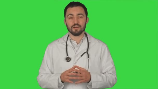 Молодой врач жестом и глядя на камеру на зеленом экране, хрома ключ — стоковое видео
