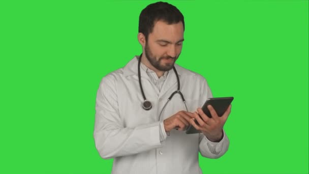 グリーンスクリーン、クロマキー上のデジタルタブレットを使用して幸せな医師 — ストック動画