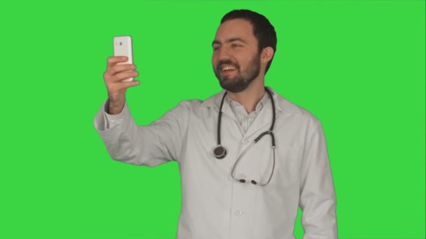 Arzt oder Sanitäter machen ein Selfie mit der Frontkamera des Smartphones auf einem grünen Bildschirm, Chroma-Schlüssel — Stockvideo