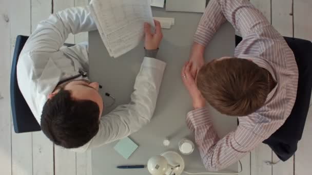 Timelapse Equipo de médicos teniendo una reunión en el consultorio médico. Vista superior — Vídeo de stock