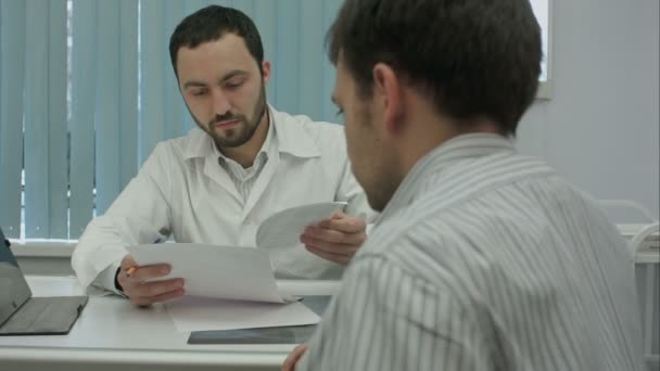 Male bearded doctor with tablet consult client. — Stock Video