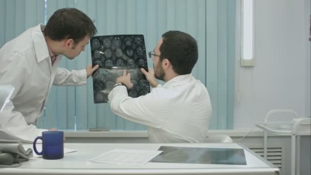 Tuteur médecin aide stagiaire avec la radiographie — Video