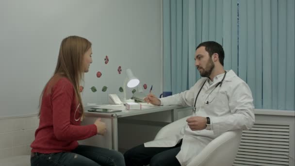 Мужчина врач в клинике дает рекомендации пациенту о таблетках — стоковое видео