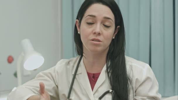 Женщина-врач говорит с оптимизмом о результатах лечения и дает рекомендации к полному выздоровлению — стоковое видео