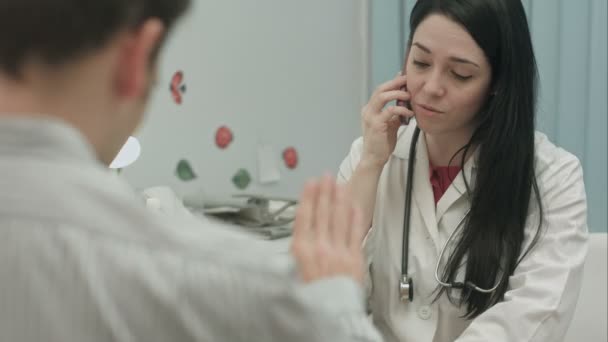 Médico teniendo una importante llamada telefónica en el consultorio médico — Vídeos de Stock