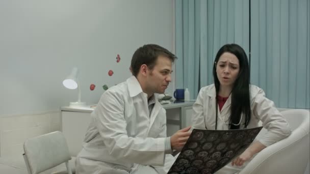 Deux médecins vérifient les patients scanner la tête, puis vient médecin avec de bonnes nouvelles de cette radiographie — Video