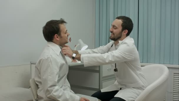 Médico masculino corrige estagiário de roupas — Vídeo de Stock