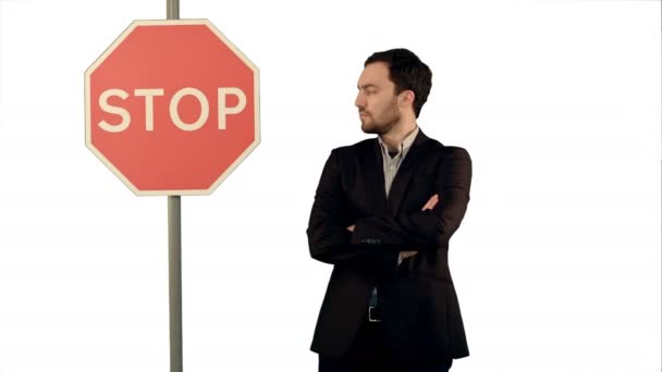 Businessman standing near a stop sign on laptop on white background isolated. — Stock Video