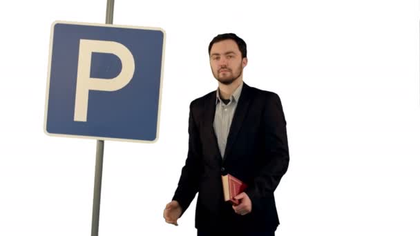 Homem lendo um livro com sinal de estacionamento no fundo branco isolado — Vídeo de Stock