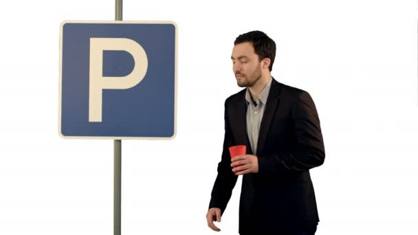 Man with cup of tea near parking sign on white background isolated — Stock Video