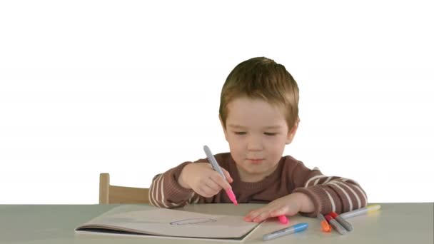 Een zoon tekening aan de tafel thuis op witte achtergrond geïsoleerd — Stockvideo