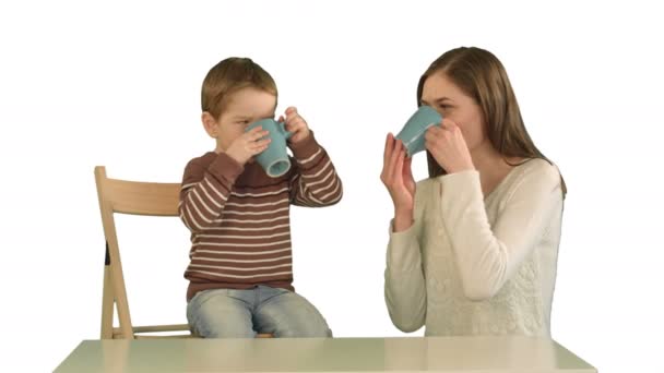 Filho com sua mãe bebendo chá no fundo branco isolado — Vídeo de Stock