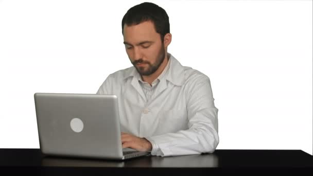年轻医生思路与便携式计算机在白色背景上桌上 — 图库视频影像