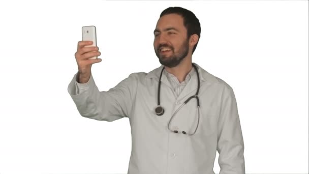 Médico o médico tomando una selfie con cámara frontal de teléfono inteligente sobre fondo blanco — Vídeos de Stock