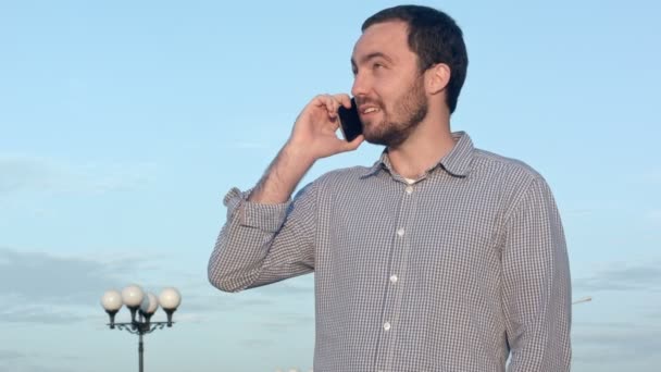 Человек разговаривает по мобильному телефону — стоковое видео