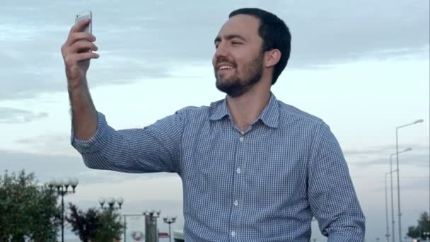 Adam kendi fotoğraflarını çekerken bir cep telefonu tutuyor — Stok video