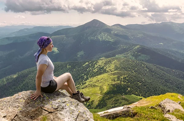 Mujer viajera se sienta y mira el borde del acantilado en el Go —  Fotos de Stock