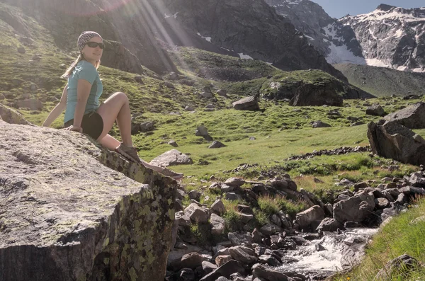 Junge Frau sitzt auf einem Felsen in den Alpen — Stockfoto