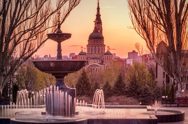 Fuente al atardecer con iglesia —  Fotos de Stock