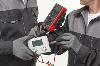 Elektrik soket voltajını dijital çokölçer ile kontrol ediyor