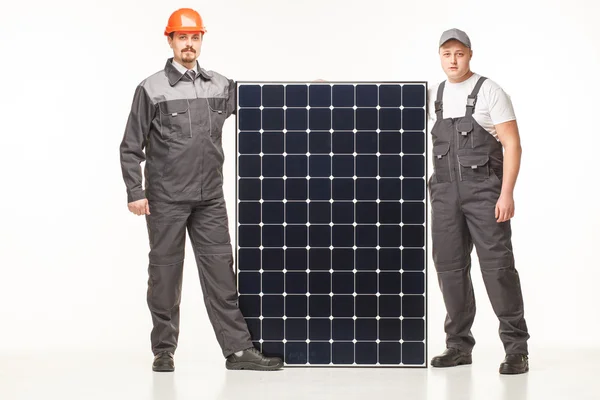 Werknemers in uniform met zonnepanelen — Stockfoto