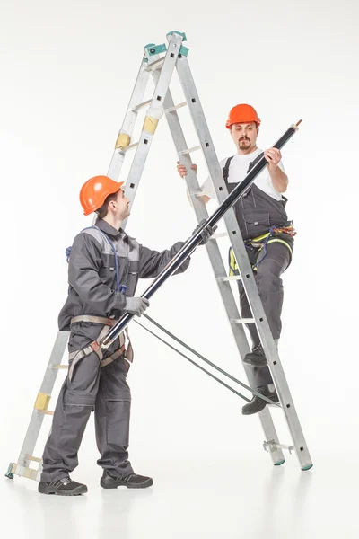 Двое рабочих на служебной лестнице — стоковое фото