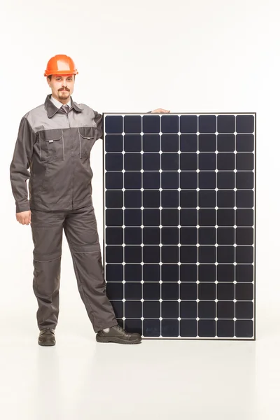 Werknemer in uniform met zonnepanelen — Stockfoto