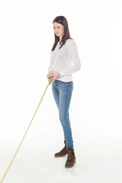 Chica con cinta de construcción medir blanco fondo oliendo — Foto de Stock