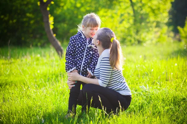 Happy young woman kissed a cute little girl — Stock Photo, Image