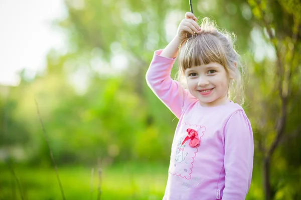 Nettes kleines Mädchen im Sommer auf dem Rasen — Stockfoto