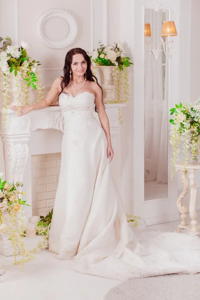 Krásná nevinná bruneta nevěsta v bílých šatech pózuje — Stock fotografie