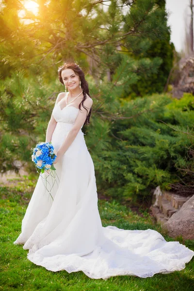 Krásná mladá brunetka nevěsta v bílé svatební šaty s závěsy, držení kytice Ukrajina — Stock fotografie