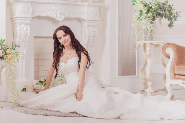 Schöne unschuldige brünette Braut im weißen Kleid posiert — Stockfoto