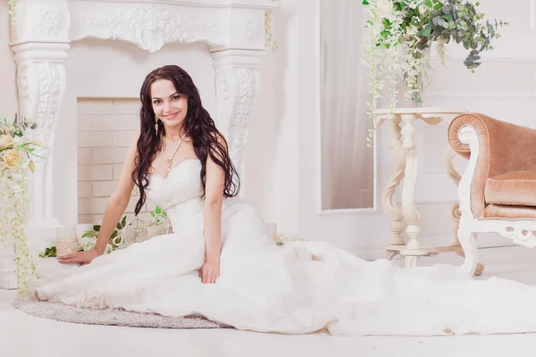 Bride sitting near fireplace — Stock Photo, Image