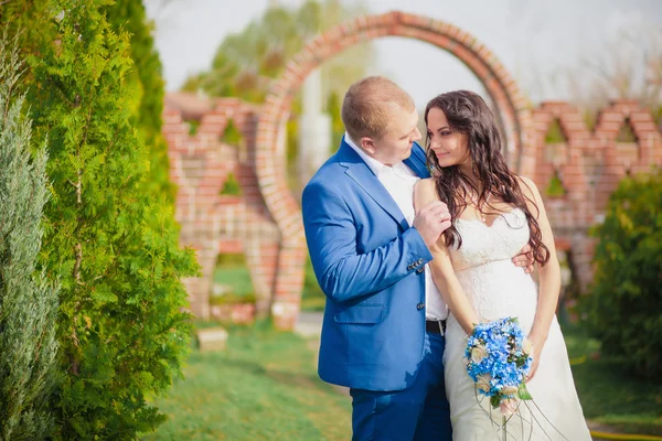 Bruid en bruidegom, kussen bij zonsondergang op gras romantisch getrouwd paar — Stockfoto