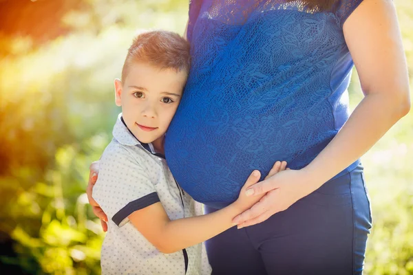 Chlapec líbat těhotná žena — Stock fotografie