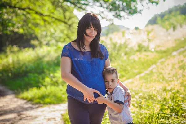 小さな男の子ハグ妊娠中の母親 — ストック写真