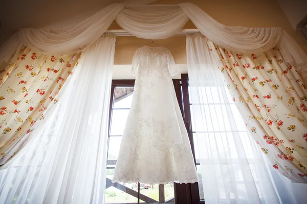 Weißes Hochzeitskleid hängt an einem Haus — Stockfoto