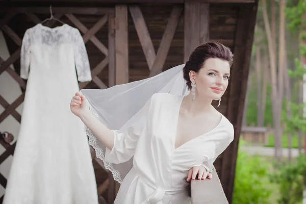 Mom and little girl help the bride to wear a wedding dress. — Stock Photo, Image