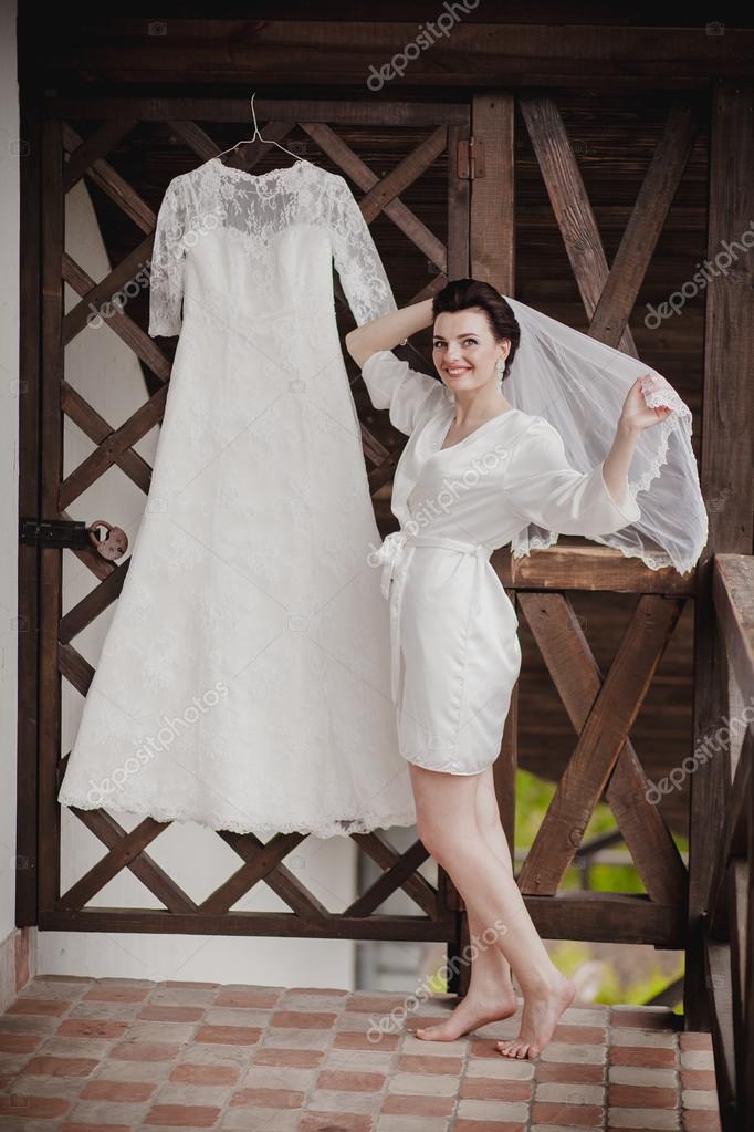 Mom And Little Girl Help The Bride To Wear A Wedding Dress