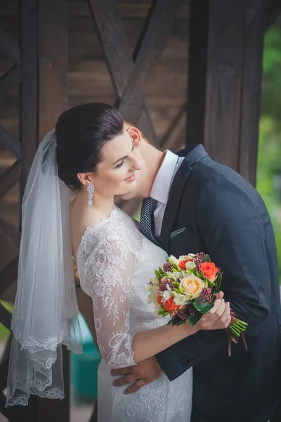 Couple de mariage, beau jeune marié debout dans un parc tenant la main et souriant — Photo