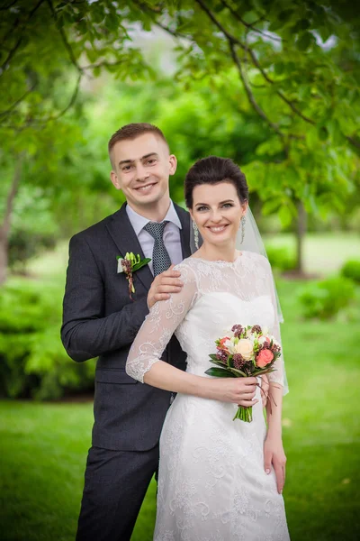 Feliz novio guapo sensual y hermosa novia en vestido blanco abrazando de cerca —  Fotos de Stock